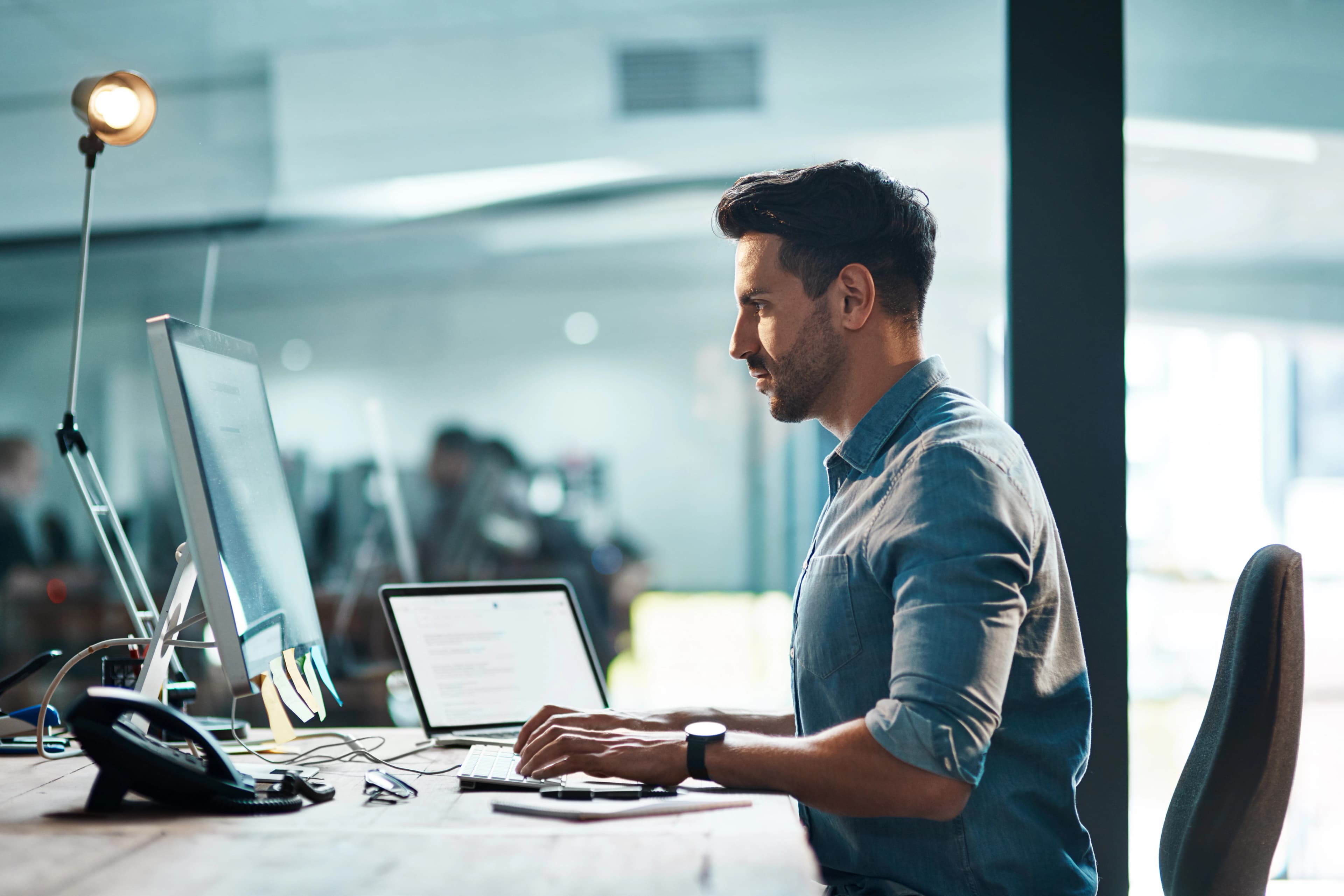 Creative professional working at a desk with multiple screens